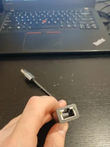 a person holding a USB Ethernet adapter